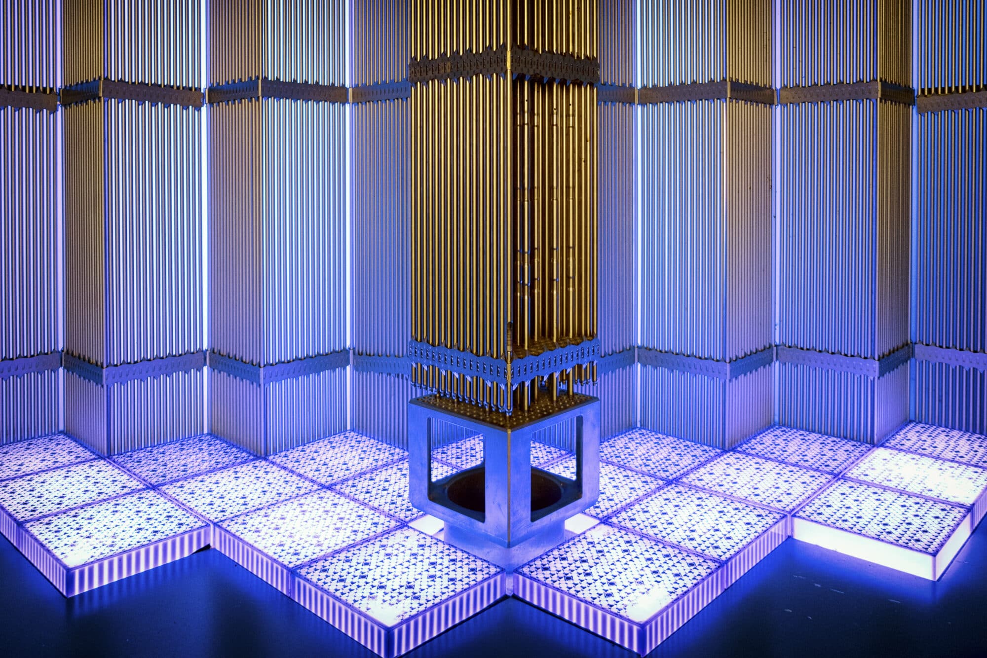 An installation featuring a tall, metallic column surrounded by illuminated panels with blue lighting.